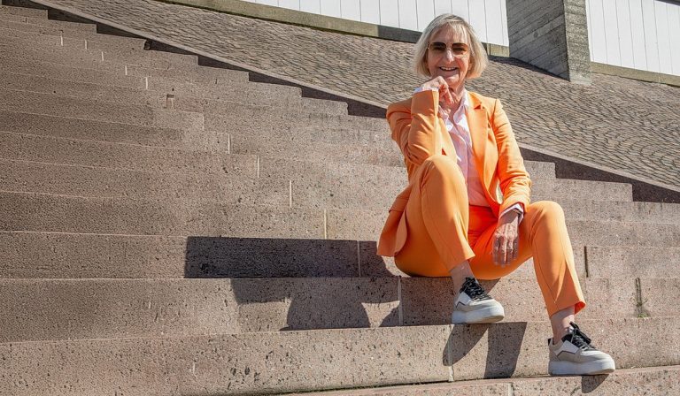 Sabine Wehrhahn steht für „ Echte Ausstrahlung statt Pose “ dazu in ihrem Businessanzug in orange auf den Treppen vor dem Sprengel-Museum! Die Hannoveraner Unternehmerin hat es geschafft „ Vom Bild zur Marke “