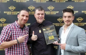 Gruppenfoto mit Calvin Hollywood – Thomas Schoo „ Personal-Branding- u. Business Fotograf “ und Danny Ziegler im Acor Boutique Hotel Heidelberg vor der Fotowand der Business Bootcamp Online Academy auf der Mastermind 2019!