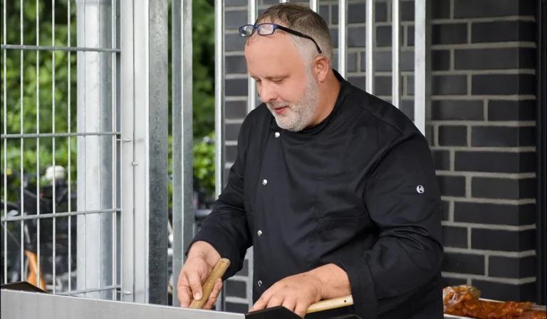 Authentische Personal Branding Fotografie von Thomas Schoo: Caterer Marco Althoff von Althoffs Landhotel fokussiert bei der Arbeit mit der Brille auf der Stirn beim Legendenspiel der Schalker Eurofighter gegen den SW Weiner in Ochtrup.