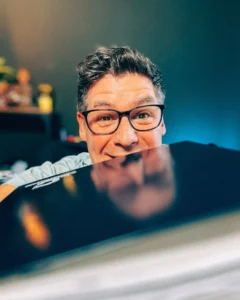 Ein inzidiertes Foto von Sascha Übler in seiner Continentale Geschäftsstelle von Sascha Übler Versicherungen! Er trägt ein blaugraues Oberhemd. Er duckt sich etwas ab um den aufgeklappten Laptop der mit Continentale Logo versehen ist in Positur zu bringen! Sein Einsatz für Absicherung für klare Planbarkeit ist stets gegeben.