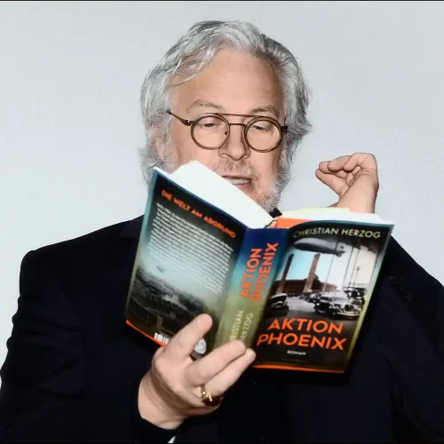 Bestsellerautor Christian Herzog (Ralf H. Dorweiler) liest fokussiert in seinem Roman „Aktion Phönix“ bei einer Autorenlesung – fotografiert von Personal Branding Fotograf Thomas Schoo.